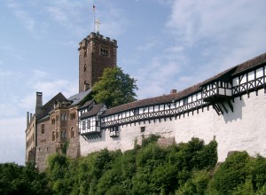 Die Wartburg bei Eisenach (Quelle: „Wartburg von Brücke“ von Lencer at de.wikipedia)